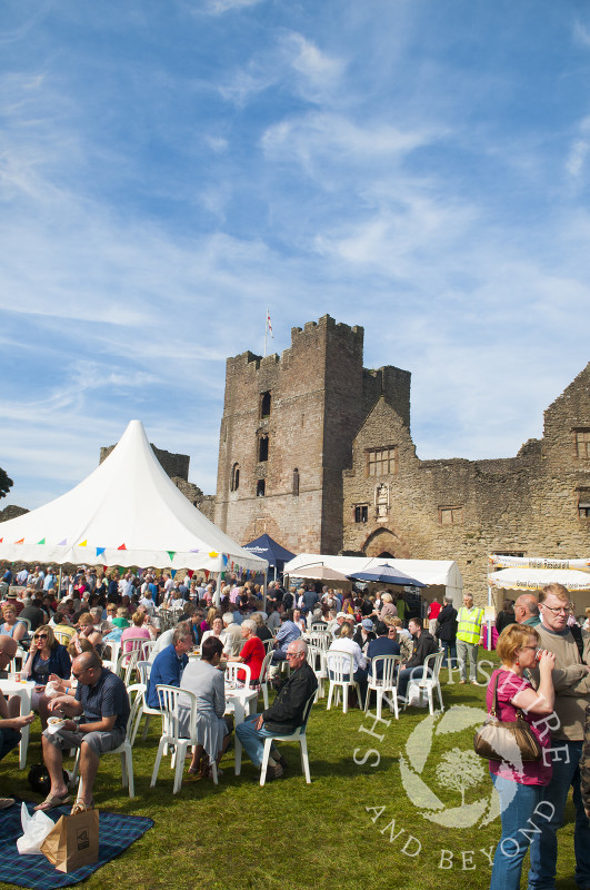 Visitors enjoy refreshments in the castle grounds during the Ludlow Food Festival, Shropshire, England.