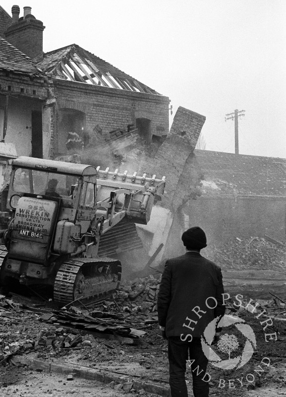 A passer-by watches as buildings are demolished in Bradford Street, Shifnal, Shropshire, in 1966.