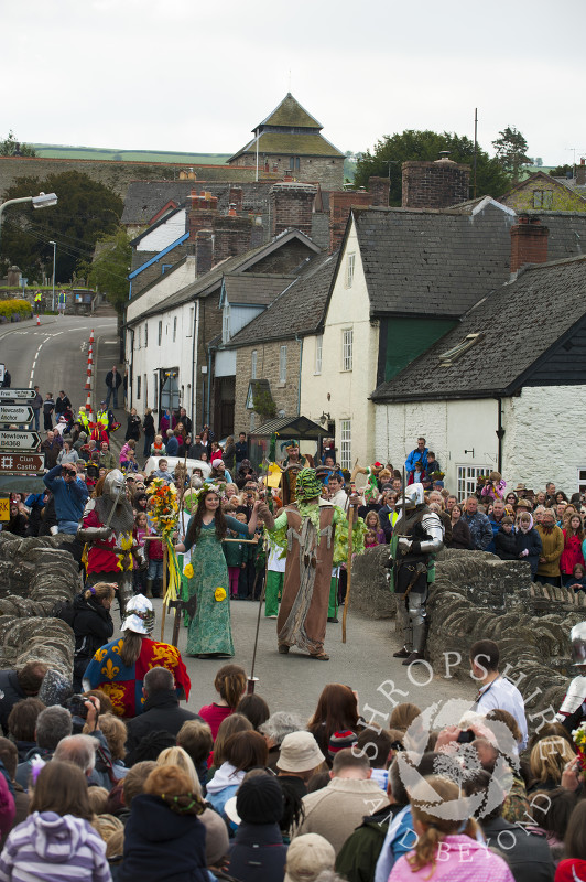 The Green Man and the May Queen in procession over the bridge at Clun Green Man Festival, Shropshire.