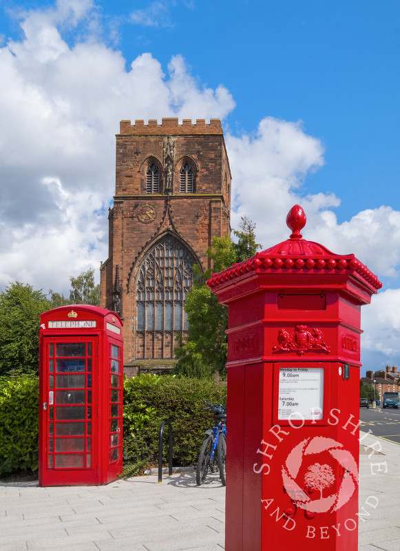 Shrewsbury Abbey with a red phone box and Penfold pillar box, Shropshire.
