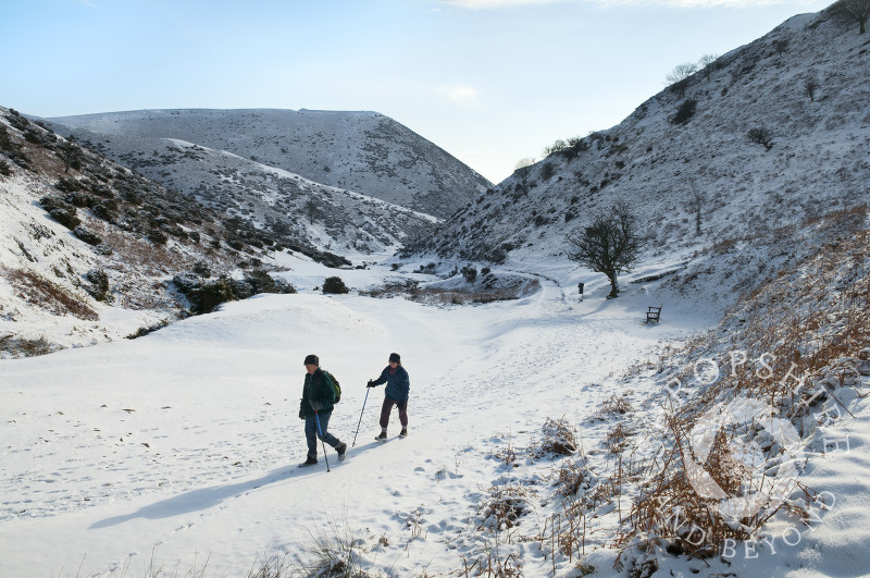 Winter walkers in the snow at Carding Mill Valley, near Church Stretton, Shropshire, England.