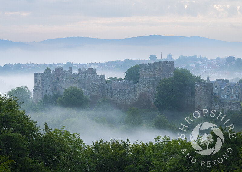 Mist swirls arounds Ludlow Castle at dawn, Shropshire.