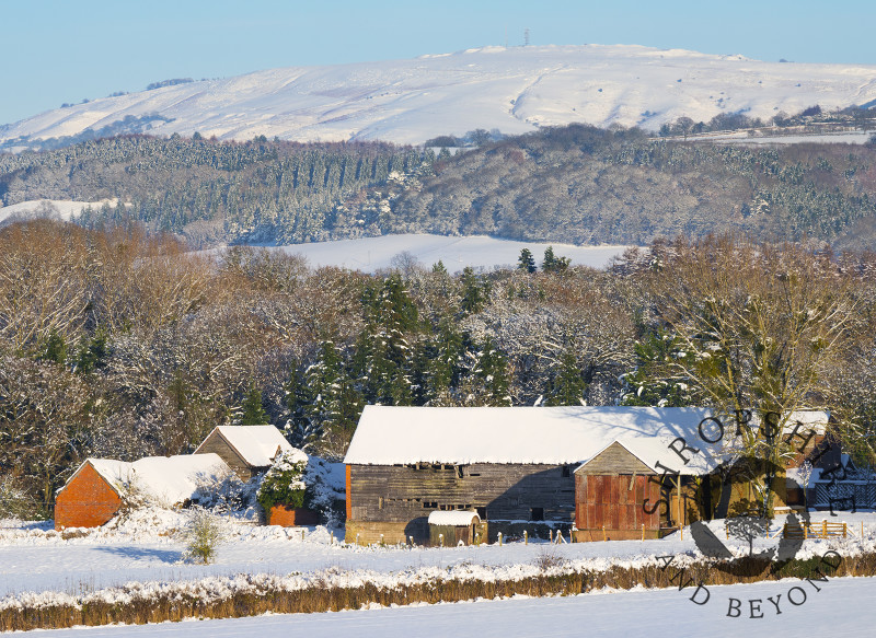 Snow surrounds an old barn near Bromfield beneath Brown Clee Hill, Shropshire.
