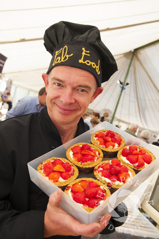 A vendor with a batch of strawberry tarts at Ludlow Food Festival, Shropshire, England.