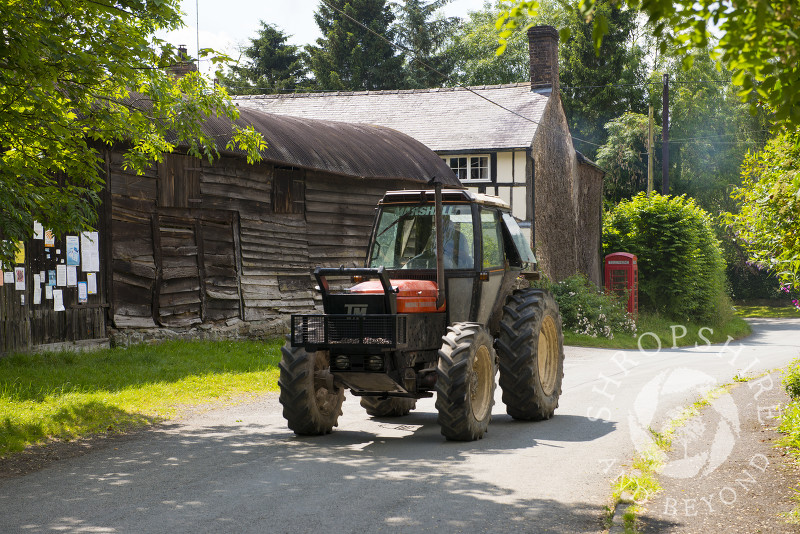 A tractor passes through the village of Hopesay near Craven Arms, Shropshire, England.