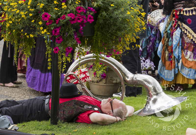 A morris dance musician has a nap at Shrewsbury Castle during the annual Shrewsbury Folk Festival, Shropshire.