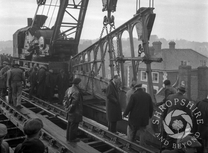 A section of the old railway bridge being lifted away, Shifnal, Shropshire, 1953.