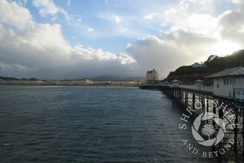 Looking along Llandudno Pier towards the Grand Hotel and the Victorian promenade at Llandudno, Wales.