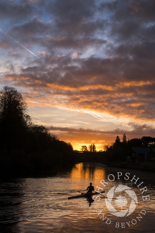 A rower at sunrise on the River Severn at Shrewsbury, Shropshire.