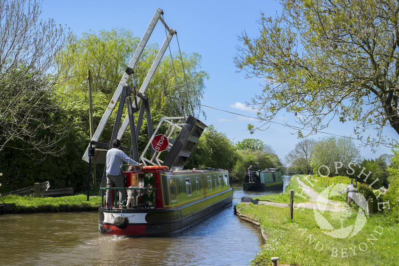 A narrowboat negotiates Morris's Lift Bridge on the Llangollen Canal near Whixall Moss, Shropshire.