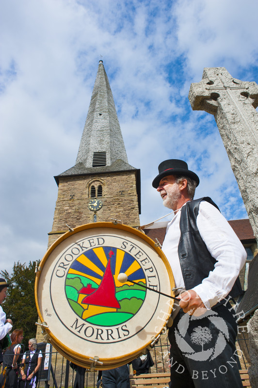 Crooked Steeple Morris dancer in front of St Mary's Church with its twisted spire at Cleobury Mortimer, Shropshire, England.