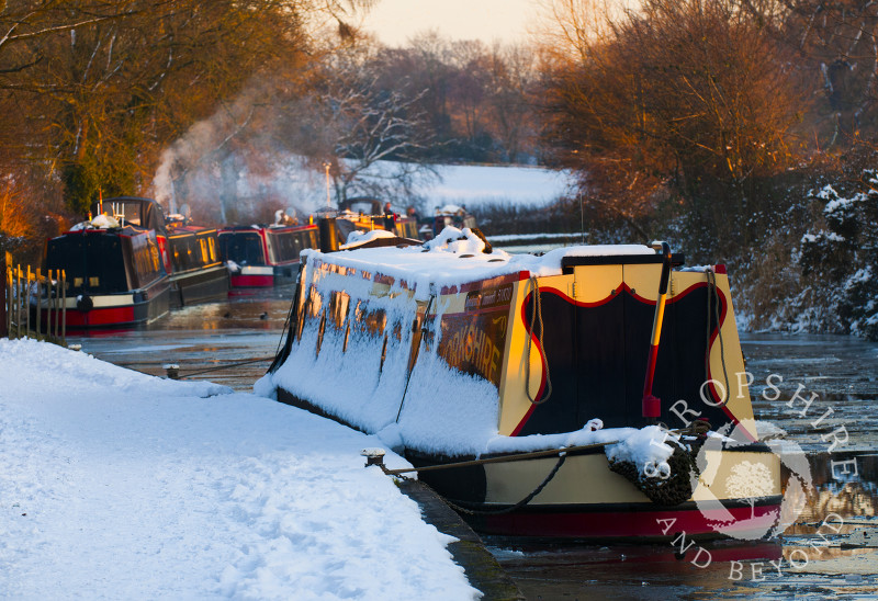 Late afternoon sunlight glistens on the winter snow along the Llangollen Canal at Ellesmere, Shropshire, England.