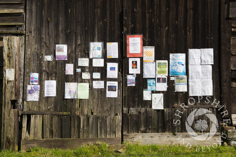 The village noticeboard on the side of an old barn in Hopesay, near Craven Arms, Shropshire, England.