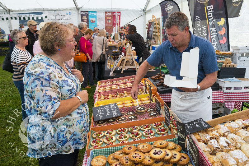 A visitor makes a selection from the Love Patisserie stall at Ludlow Food Festival, Shropshire.