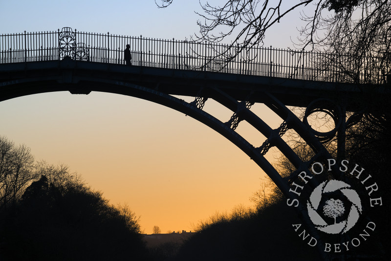 A lone figure on the Iron Bridge at sunrise, Ironbridge, Shropshire, England.