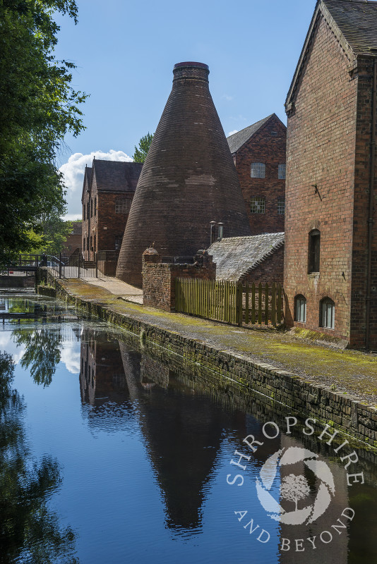 A bottle kiln at Coalport China Museum reflected in the water of the Shropshire Canal at Coalport, near Ironbridge, Shropshire.