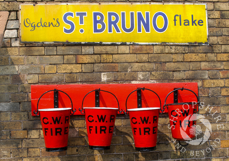 Fire buckets and advertising signs on the platform at Hampton Loade Station, Severn Valley Railway, Shropshire, England.