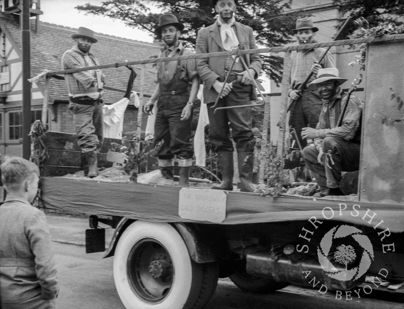 The Broadway Brewery Gold Diggers float passes the Fire Station in Shrewsbury Road, Shifnal, Shropshire, during the carnival procession in the 1950s.