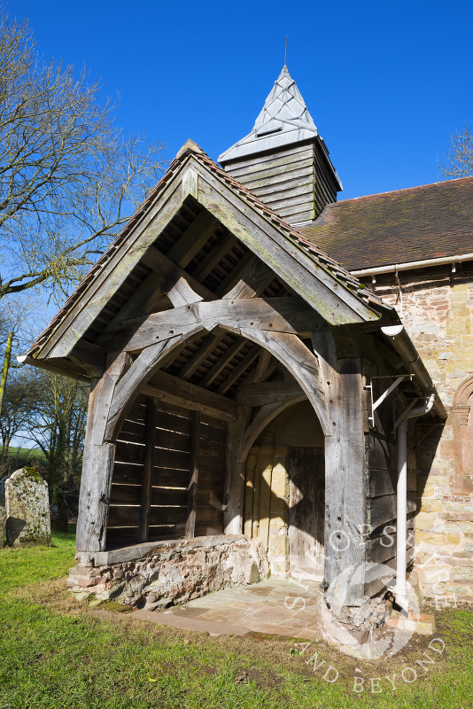 The wooden porch with stone seats at St Michael's Church, Upton Cressett, Shropshire, England.