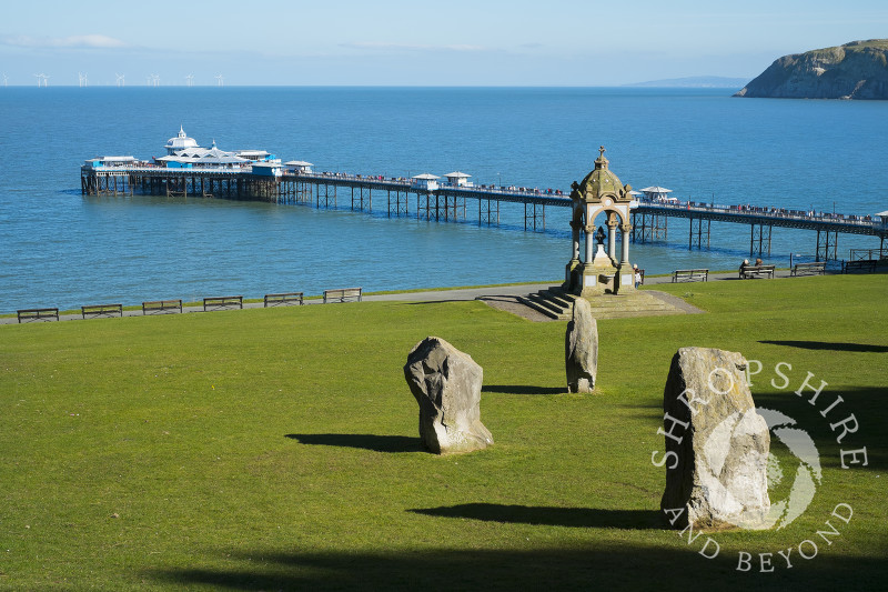 Happy Valley Gardens stone circle and Victorian drinking fountain looking to Llandudno Pier, North Wales.