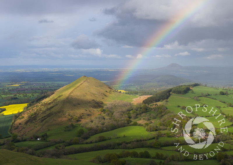 A rainbow beside the Lawley with the Wrekin on the horizon, seen from Caer Caradoc, Shropshire.