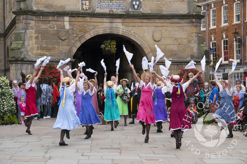 The Shrewsbury Lasses dancing in front of the Old Market Hall during Shrewsbury Folk Festival, Shropshire, England.