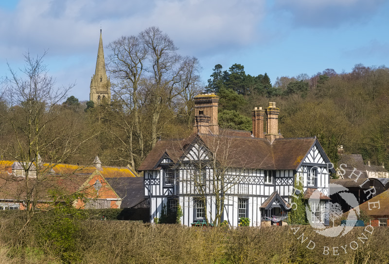 The spire of All Saints' Church overlooks a black and white farmhouse at Clive, Shropshire.