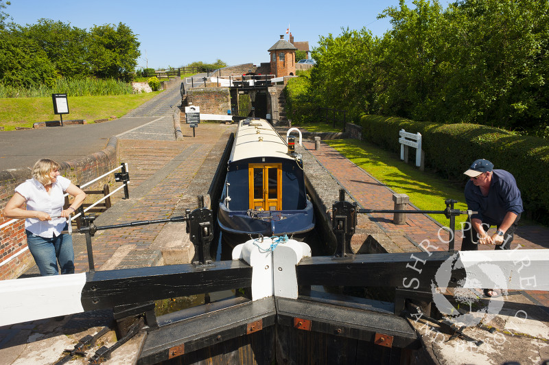 A canal boat passing through Bratch Locks at Wombourne, Staffordshire, England.