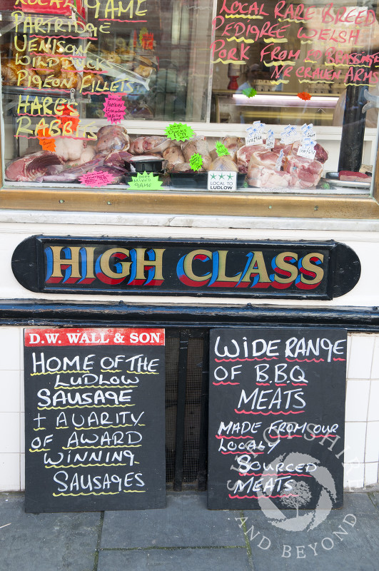 Signs outside D W Wall & Son's butchers shop during Ludlow Food Festival, Shropshire, England.