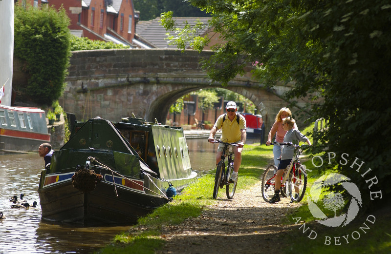 Cyclists riding along the Shropshire Union Canal at Gnosall, Staffordshire, England.