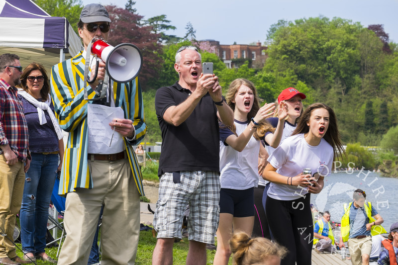 A steward directs operations while team mates cheer on their crew at Shrewsbury Regatta on the River Severn in Shropshire.