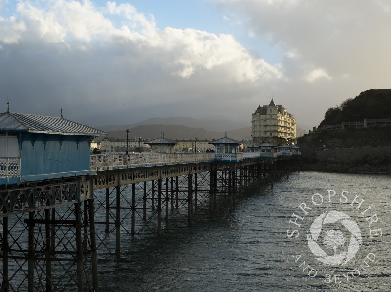 Looking along Llandudno Pier towards the Grand Hotel and the Victorian promenade at Llandudno, Wales.