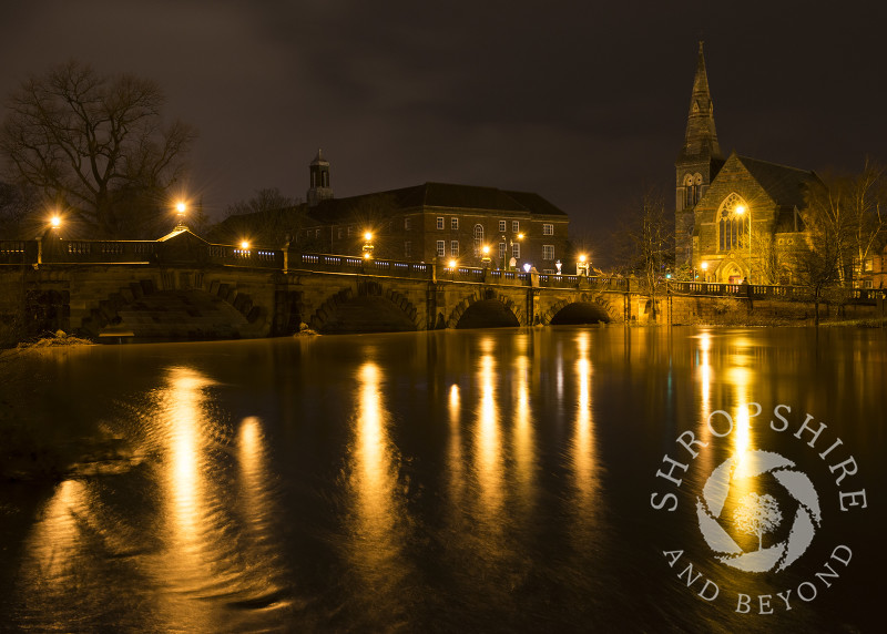 Lights on English Bridge reflected in the swollen River Severn in Shrewsbury, Shropshire.