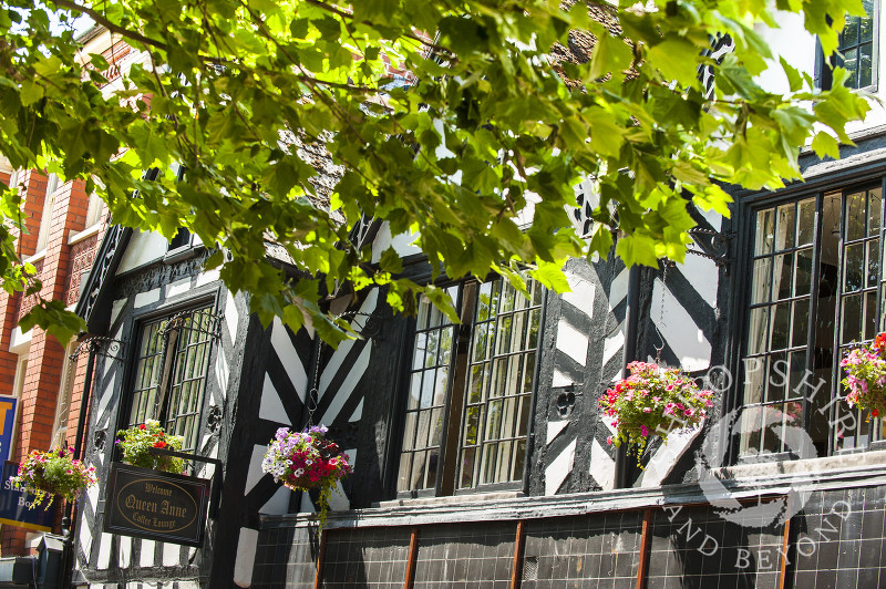 Hanging baskets outside the Queen Anne Coffee Lounge in Oswestry, Shropshire, England.