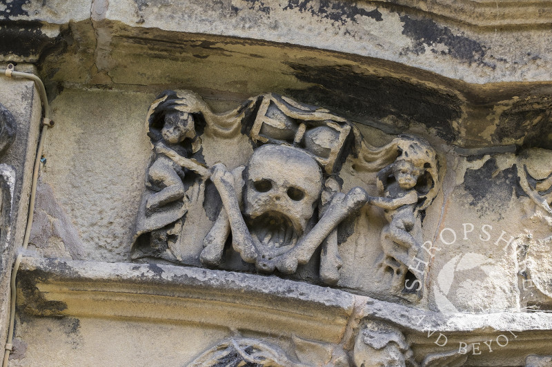 Stonework memento mori on the exterior of Holy Trinity Church in Minsterley, Shropshire.