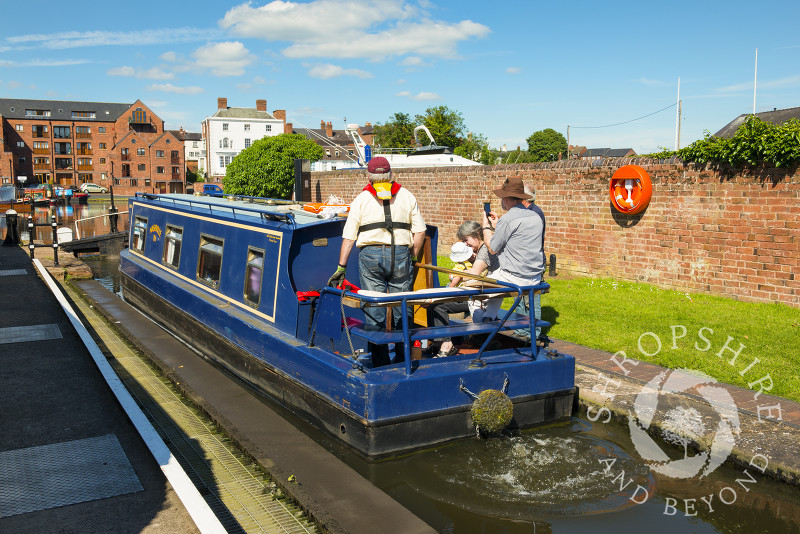 A narrowboat passes through a lock in the canal basin at Stourport-on-Severn, Worcestershire, England.