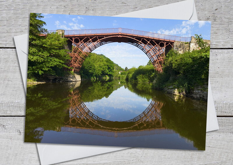 The Iron Bridge reflected in the River Severn at Ironbridge, Shropshire.