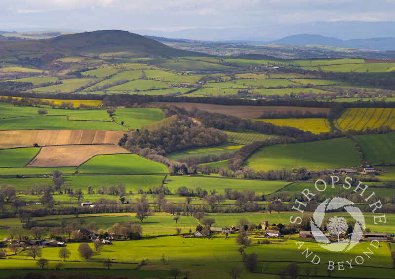 The village of Holdgate, with Caer Caradoc on the horizon, seen from Brown Clee Hill, Shropshire.