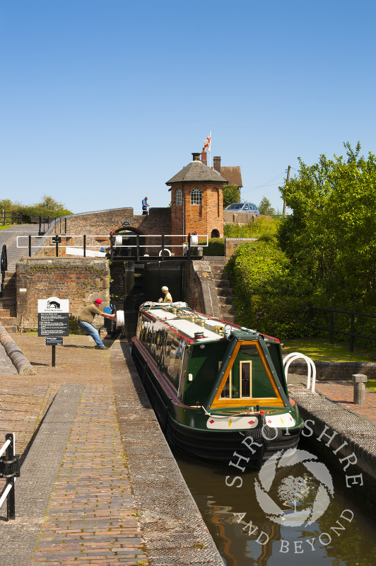 A canal boat passing through Bratch Locks at Wombourne, Staffordshire, England.