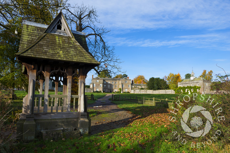 Autumn sunshine on 16th century Morville Hall and the lych gate of St Gregory's Church at Morville, near Bridgnorth, Shropshire, England.