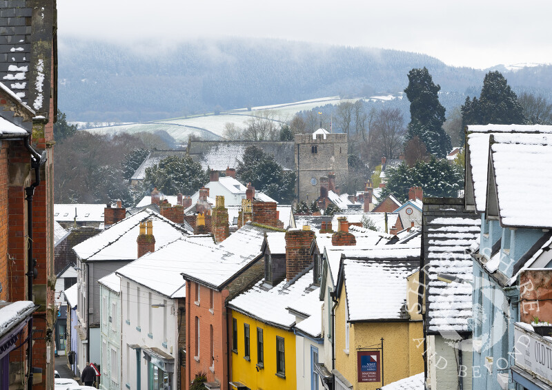 Snow-covered rooftops and St John's Church in Bishop's Castle, Shropshire.