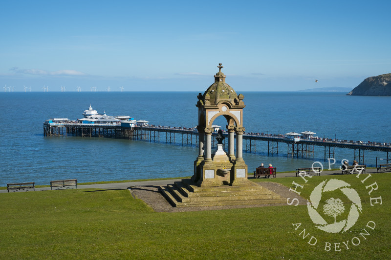 Victorian drinking fountain in Happy Valley Gardens looking to Llandudno Pier, North Wales.