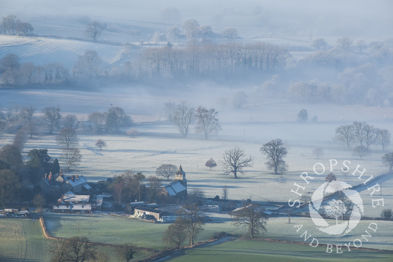 St Mary's Church at Bitterley emerging from the mist in the frosty Shropshire landscape, seen from Titterstone Clee.