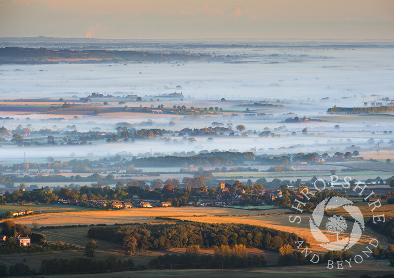 Autumn mist rolls across the Shropshire landscape beyond the village of Wrockwardine, seen from the summit of the Wrekin, England.