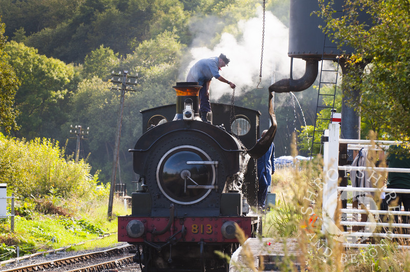 A GWR 813 0-6-0 saddle tank locomotive fills up with water at Highley Station, Severn Valley Railway, Shropshire, England.