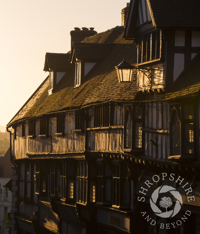 Sunrise illuminates half-timbered buildings on Wyle Cop, Shrewsbury, Shropshire.