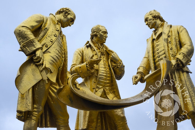 The bronze statue of Matthew Boulton, James Watt and William Murdoch in front of the Library of Birmingham, England, UK. The statue is known locally as the Golden Boys.