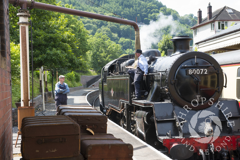 A steam locomotive taking on water at Llangollen station, Denbighshire, Wales.
