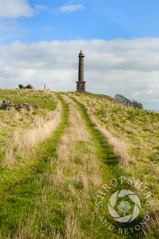 A grassy track leads to Rodney's Pillar on Breidden Hill, Powys, Wales.