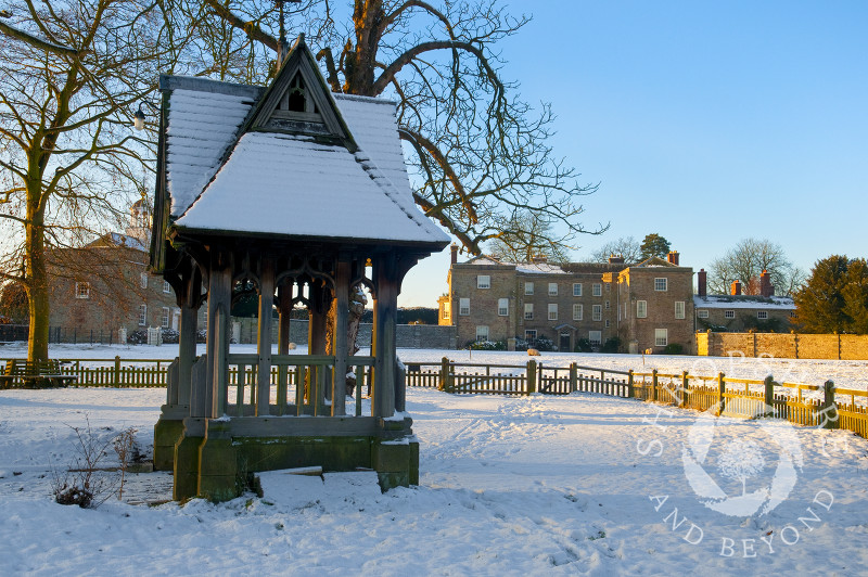 Winter snow surrounds Morville Hall and the lych gate of St Gregory's Church at Morville, near Bridgnorth, Shropshire, England.